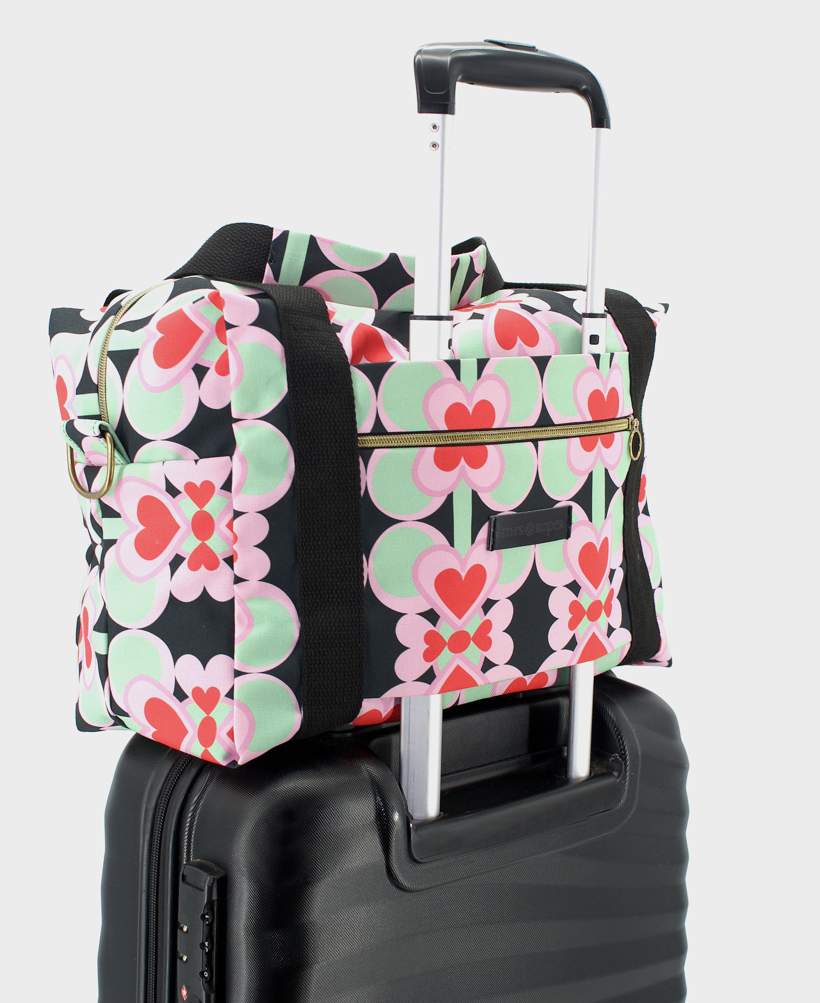 Bolsa de viaje hecha de tejido reciclado RPET con estampado de corazones en rojo y rosa sobre fondo negro de la marca Mrs. Roper.