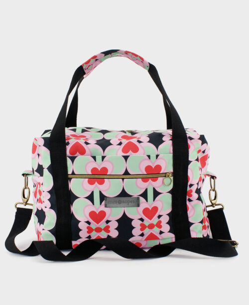 Bolsa de viaje hecha de tejido reciclado RPET con estampado de corazones en rojo y rosa sobre fondo negro de la marca Mrs. Roper.