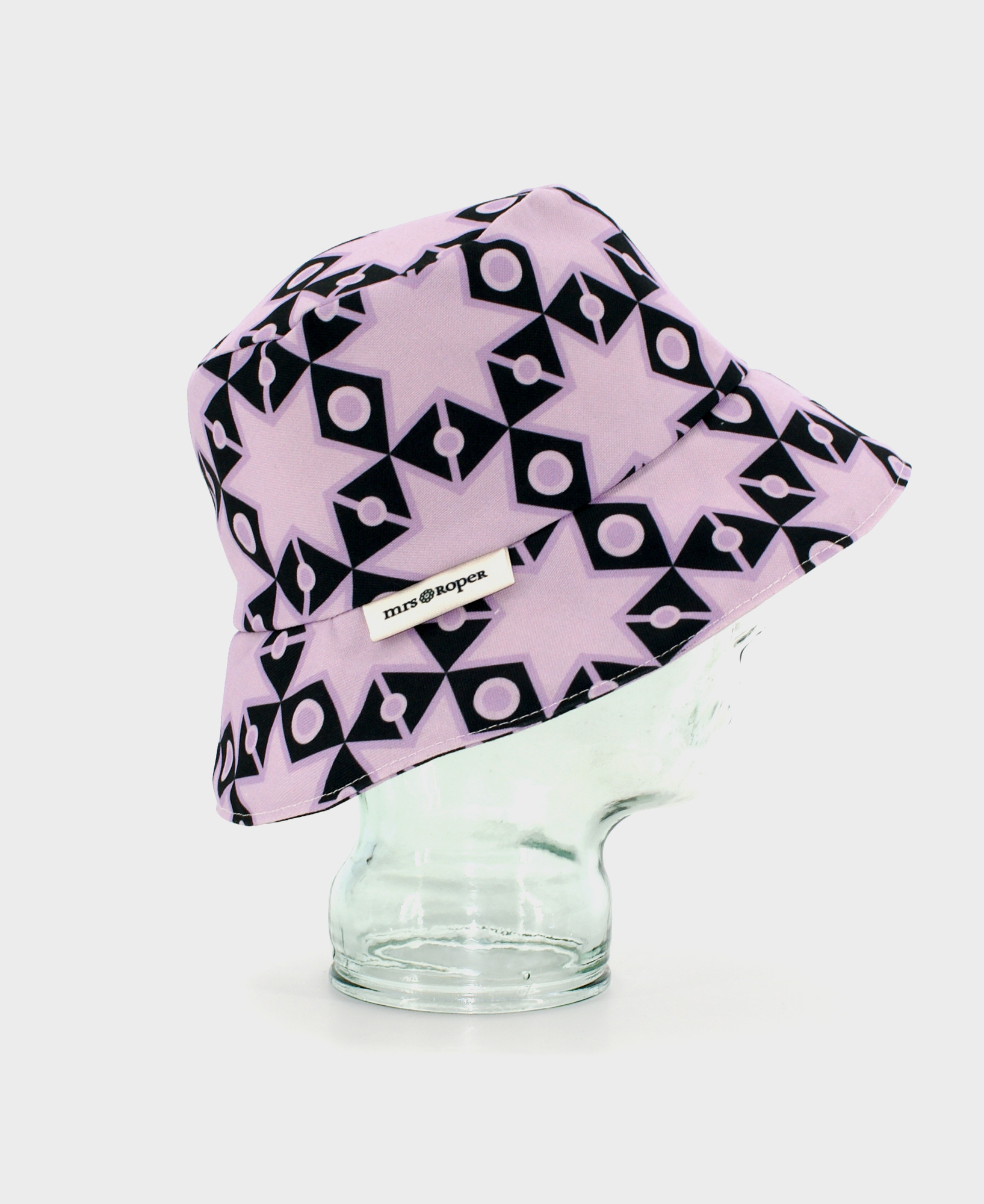 Gorro tipo bucket, con estampado de estrellas geométrico en negro y lila, realizado en tejido reciclado RPET de la marca mrs Roper.