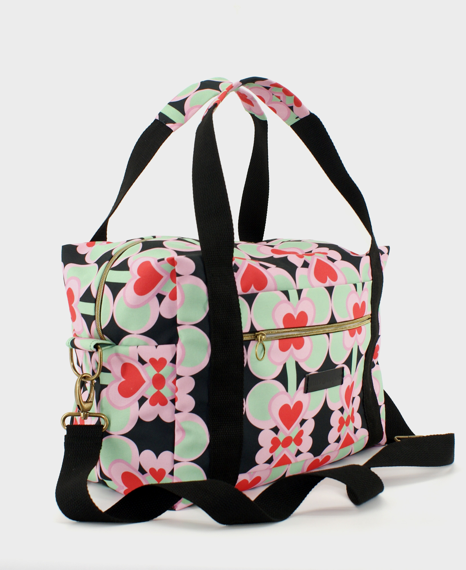 Bolsa de viaje hecha de tejido reciclado RPET con estampado de corazones en rojo y rosa sobre fondo negro de la marca Mrs. Roper.
