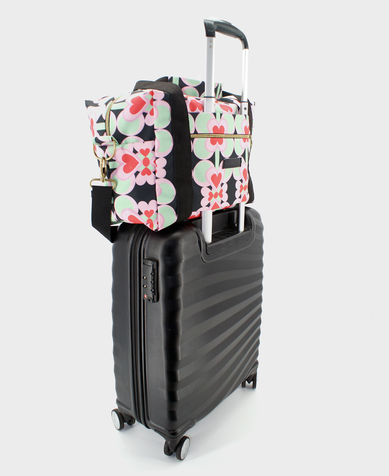 Bolsa de viaje hecha de tejido reciclado RPET con estampado de corazones en rojo y rosa sobre fondo negro de la marca Mrs. Roper.