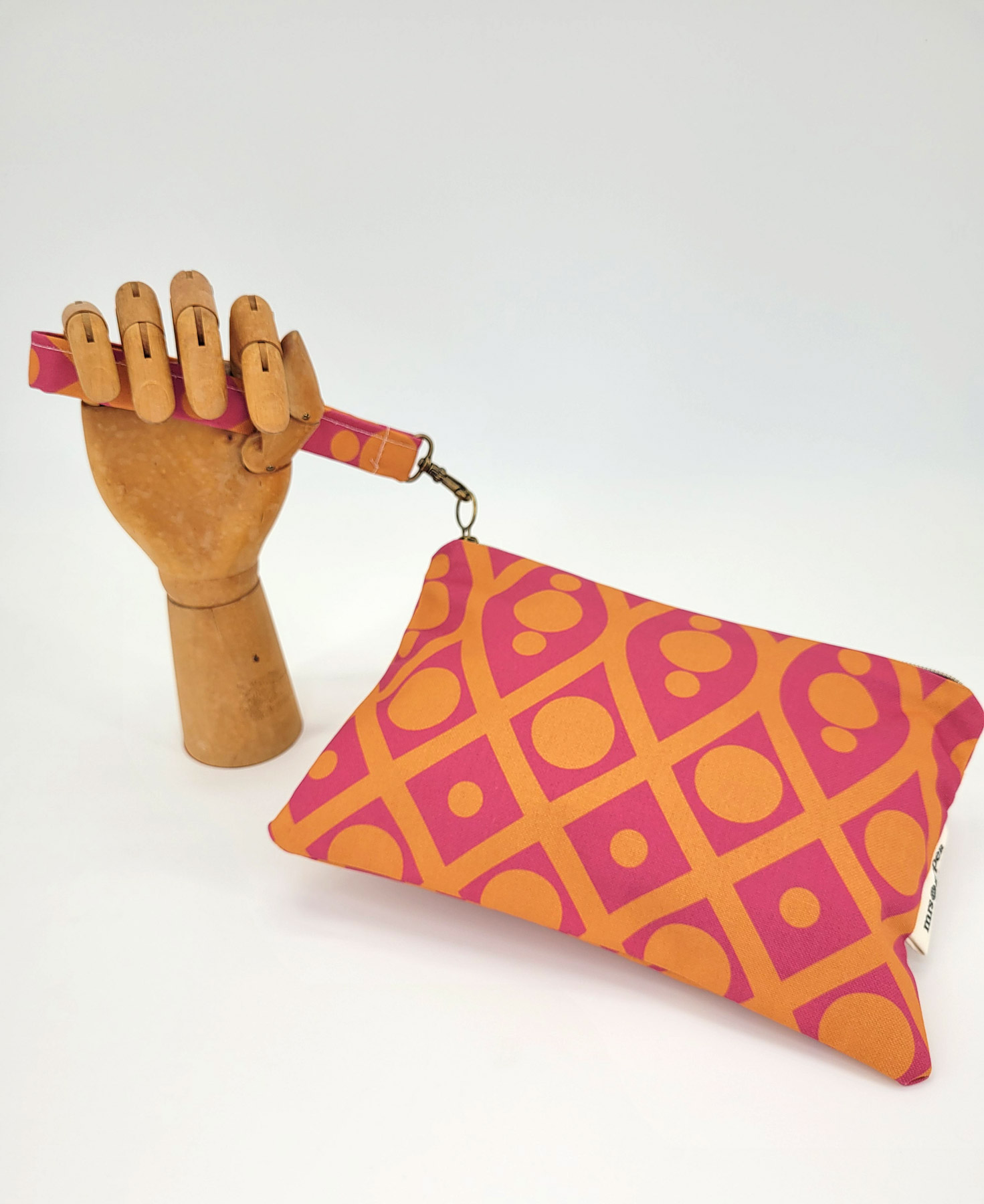 Bolso de mano con asa en tejido reciclado RPET, con estampado geométrico en naranja y fucsia de la marca Mrs. Roper.