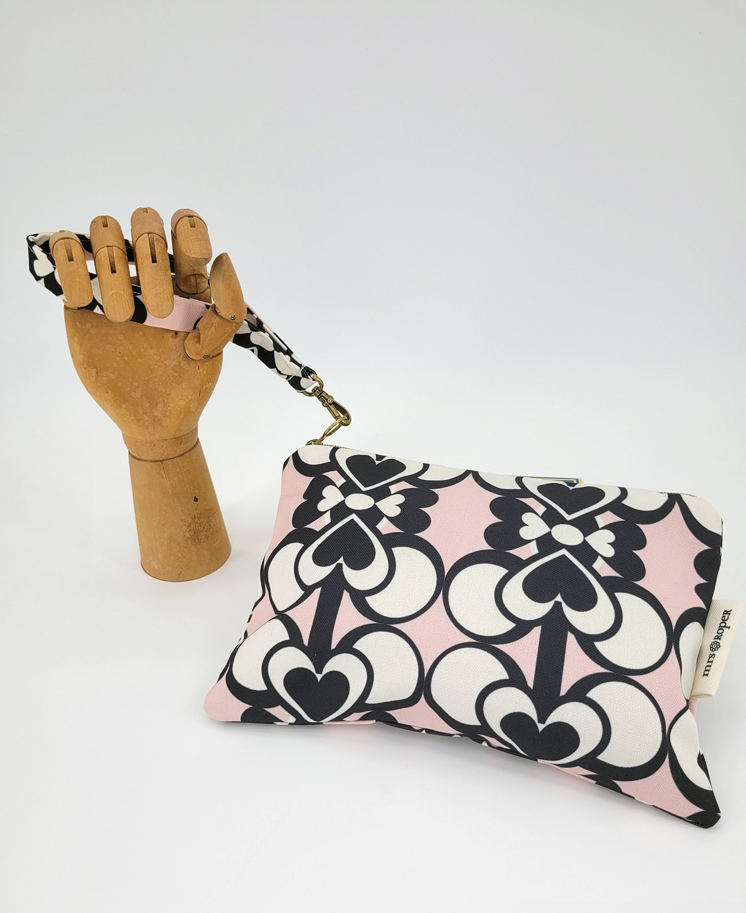 Bolso de mano con asa en tejido reciclado RPET, con estampado geométrico de corazones en blanco y negro con fondo rosa de la marca Mrs. Roper.