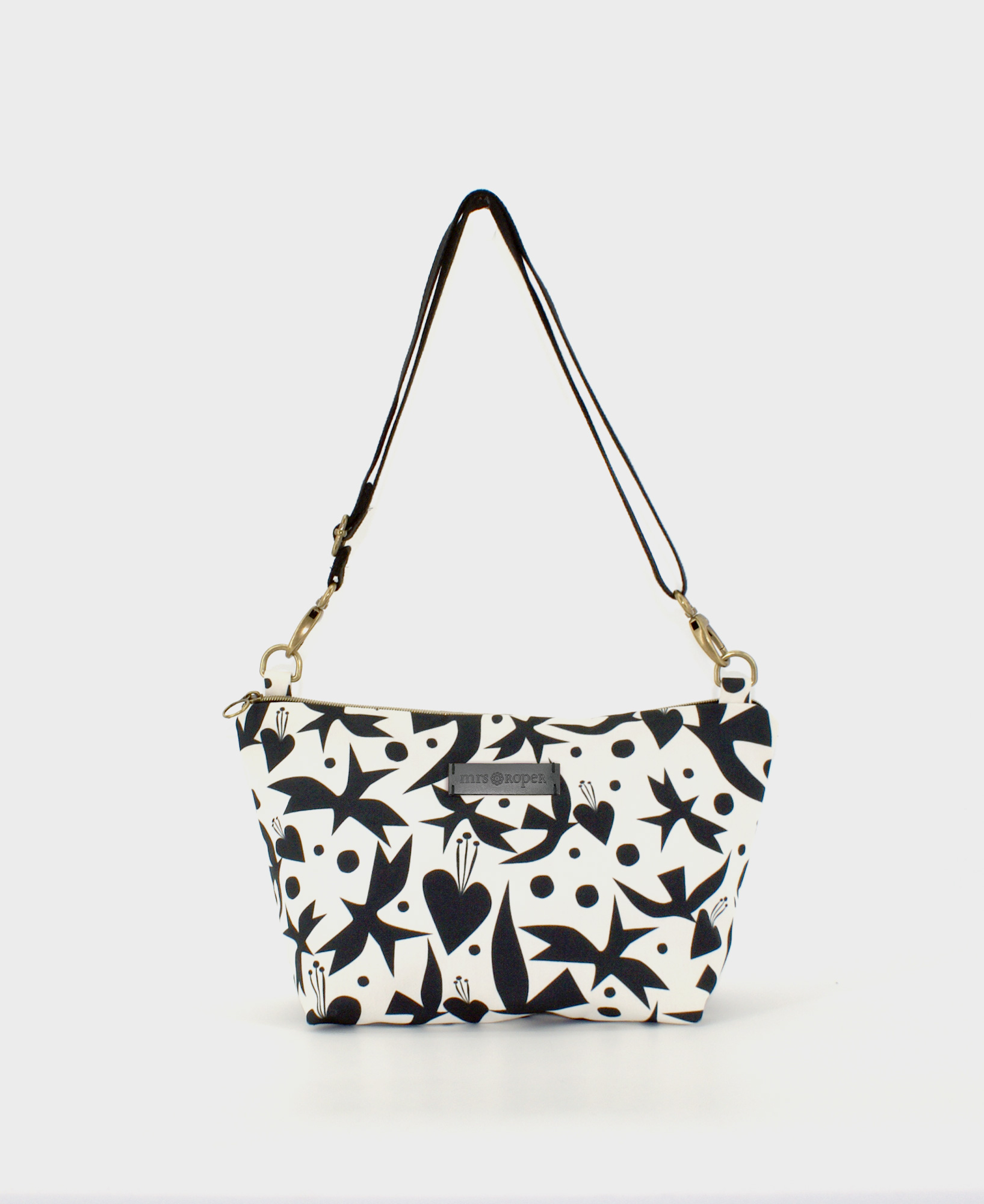 Bandolera de mujer mediana, realizada en tejido reciclado de botellas de plástico RPET, con estampado geométrico de pájaros y corazones en blanco y negro, de la marca Mrs. Roper