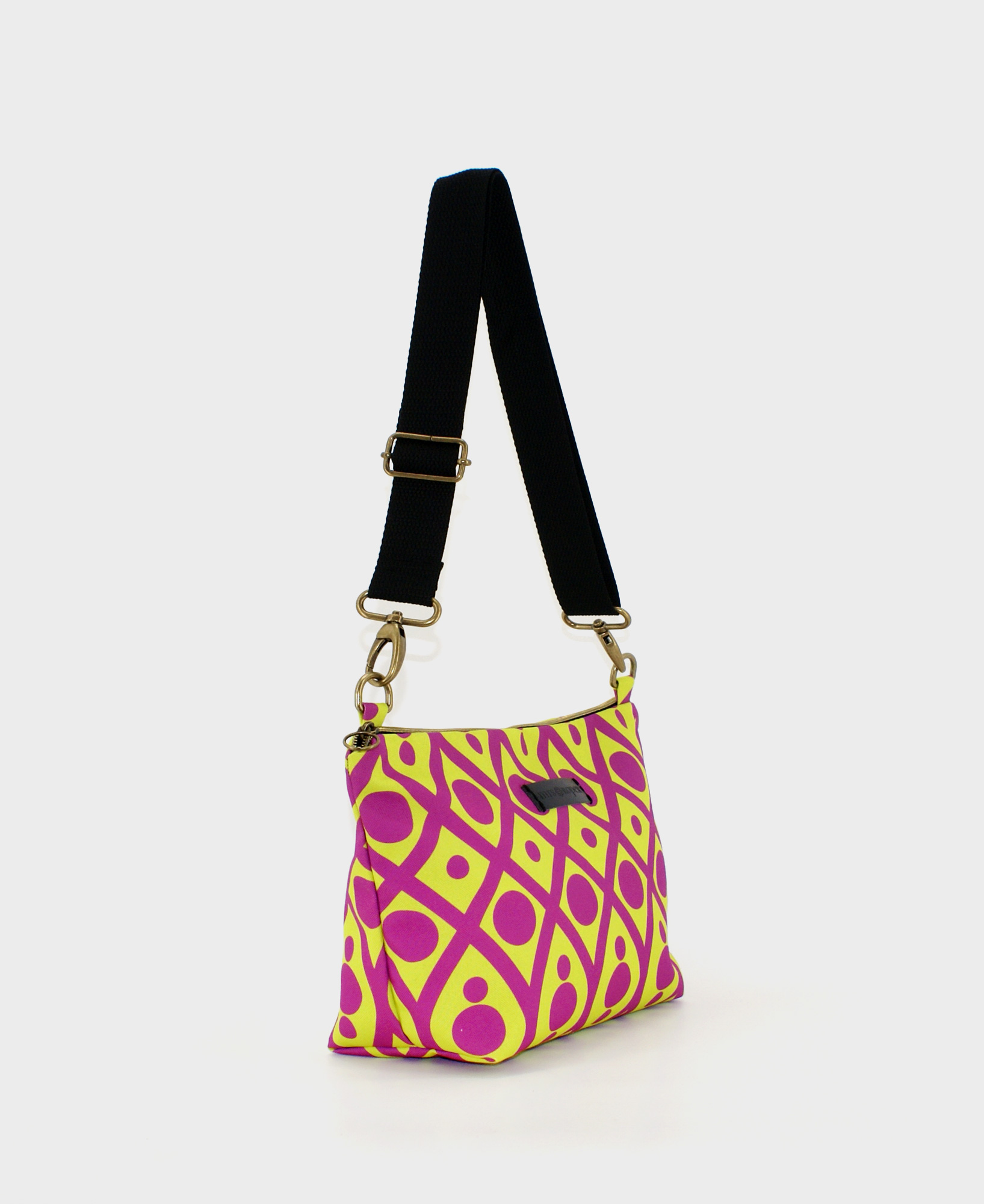 Bandolera mediana de mujer, realizada en tejido reciclado de botellas de plástico RPET, con estampado geométrico en lima y morado de la marca Mrs. Roper.