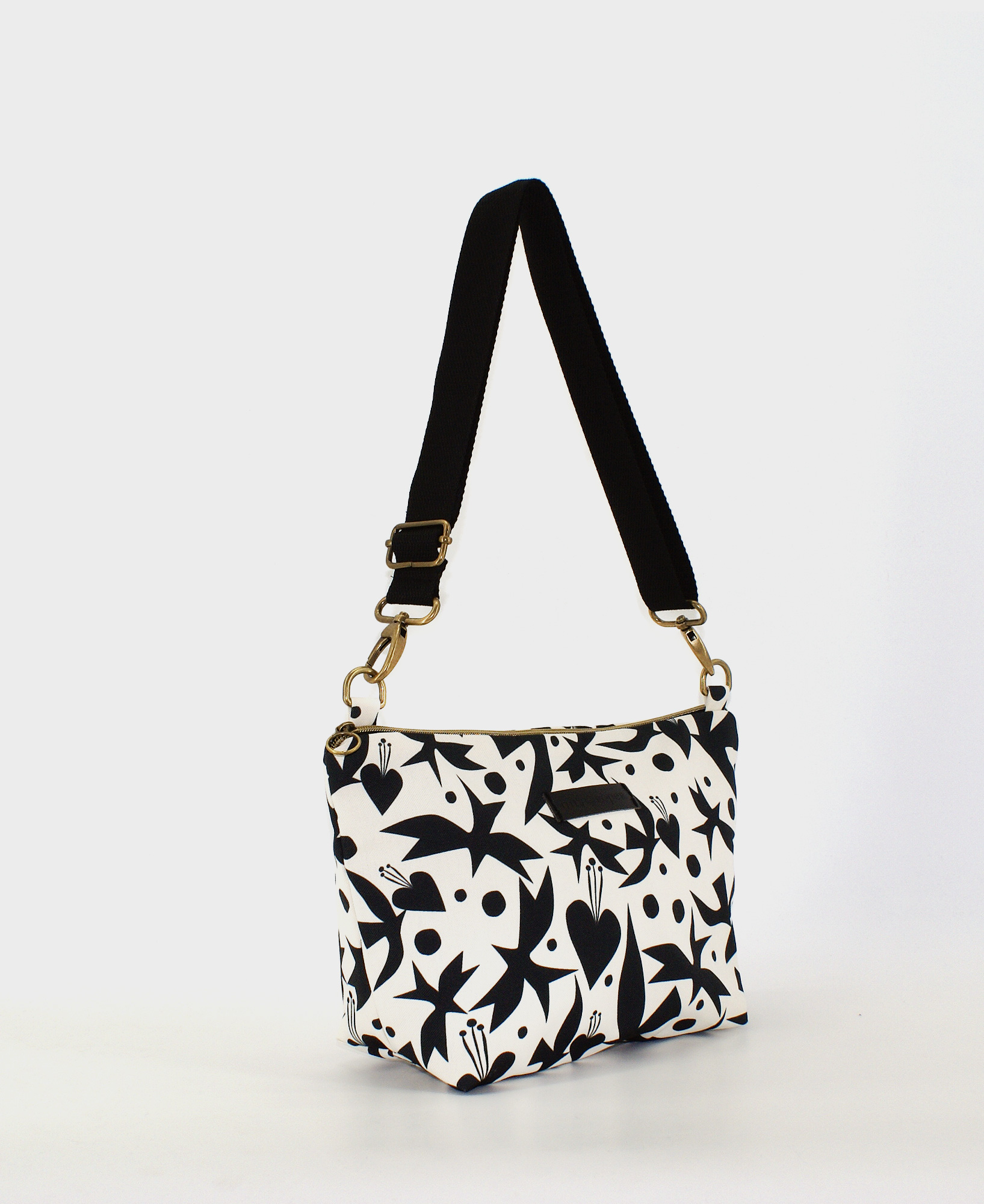 Bandolera de mujer mediana, realizada en tejido reciclado de botellas de plástico RPET, con estampado de pájaros y corazones en blanco y negro, de la marca Mrs. Roper
