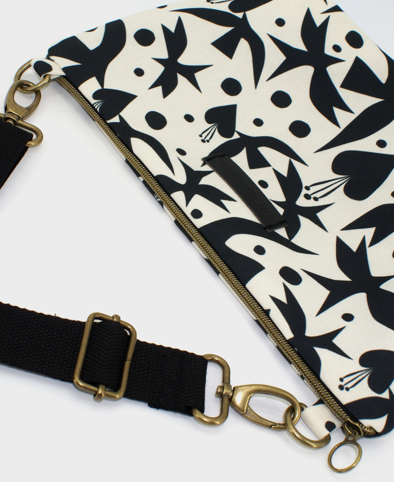 Bandolera de mujer mediana, realizada en tejido reciclado de botellas de plástico RPET, con estampado de pájaros y corazones en blanco y negro, de la marca Mrs. Roper