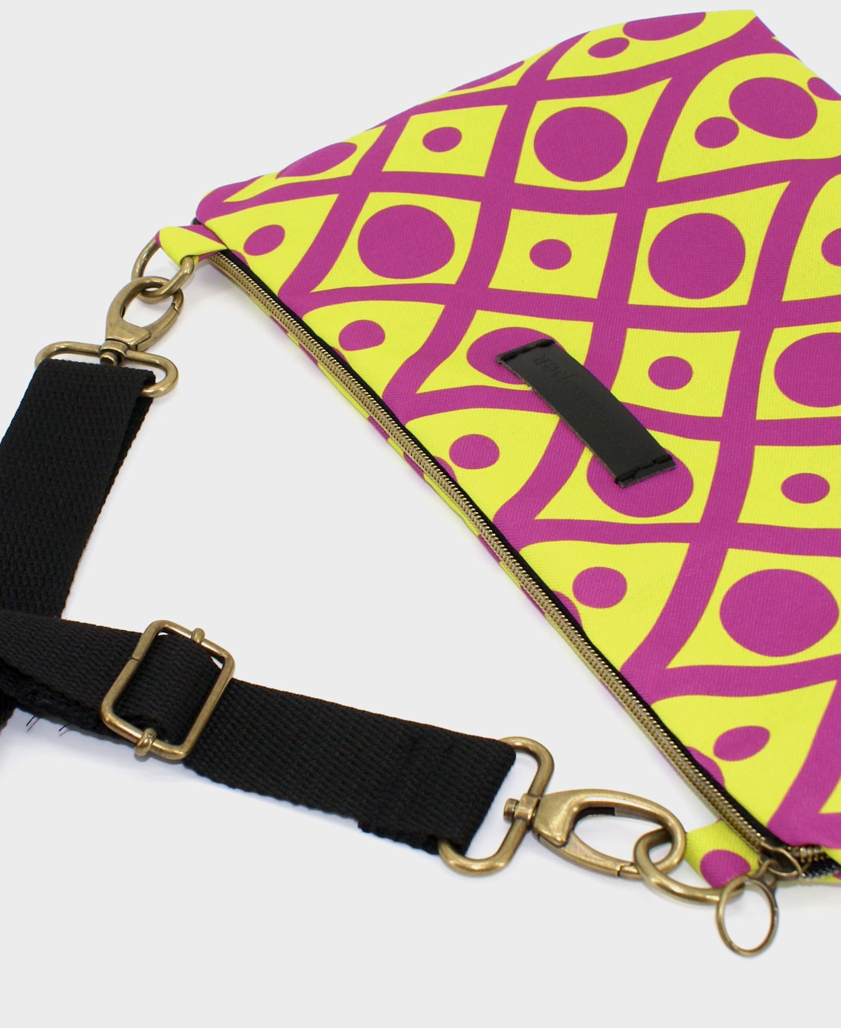 Bandolera mediana de mujer, realizada en tejido reciclado de botellas de plástico RPET, con estampado geométrico en lima y morado, de la marca Mrs. Roper.