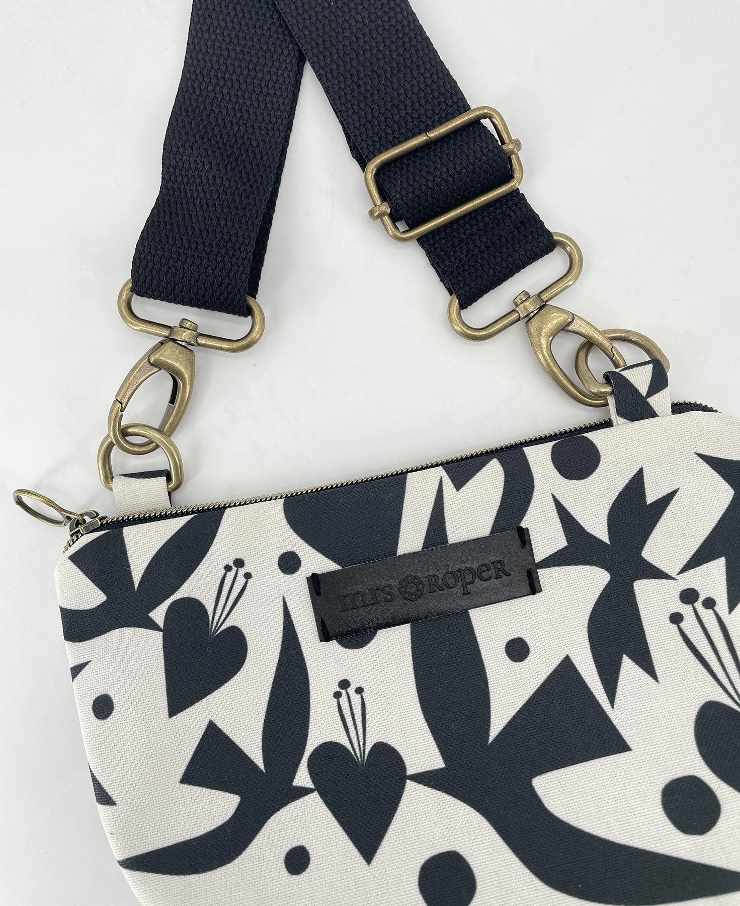 Bandolera pequeña de mujer realizada en tejido reciclado RPET con estampado de pájaros y corazones en blanco y negro, de la marca Mrs. Roper.