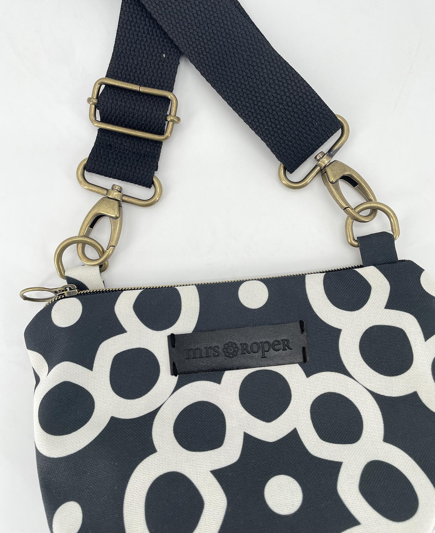 Bandolera pequeña de mujer realizada en tejido reciclado RPET con estampado geométrico en blanco y negro, de la marca Mrs. Roper.