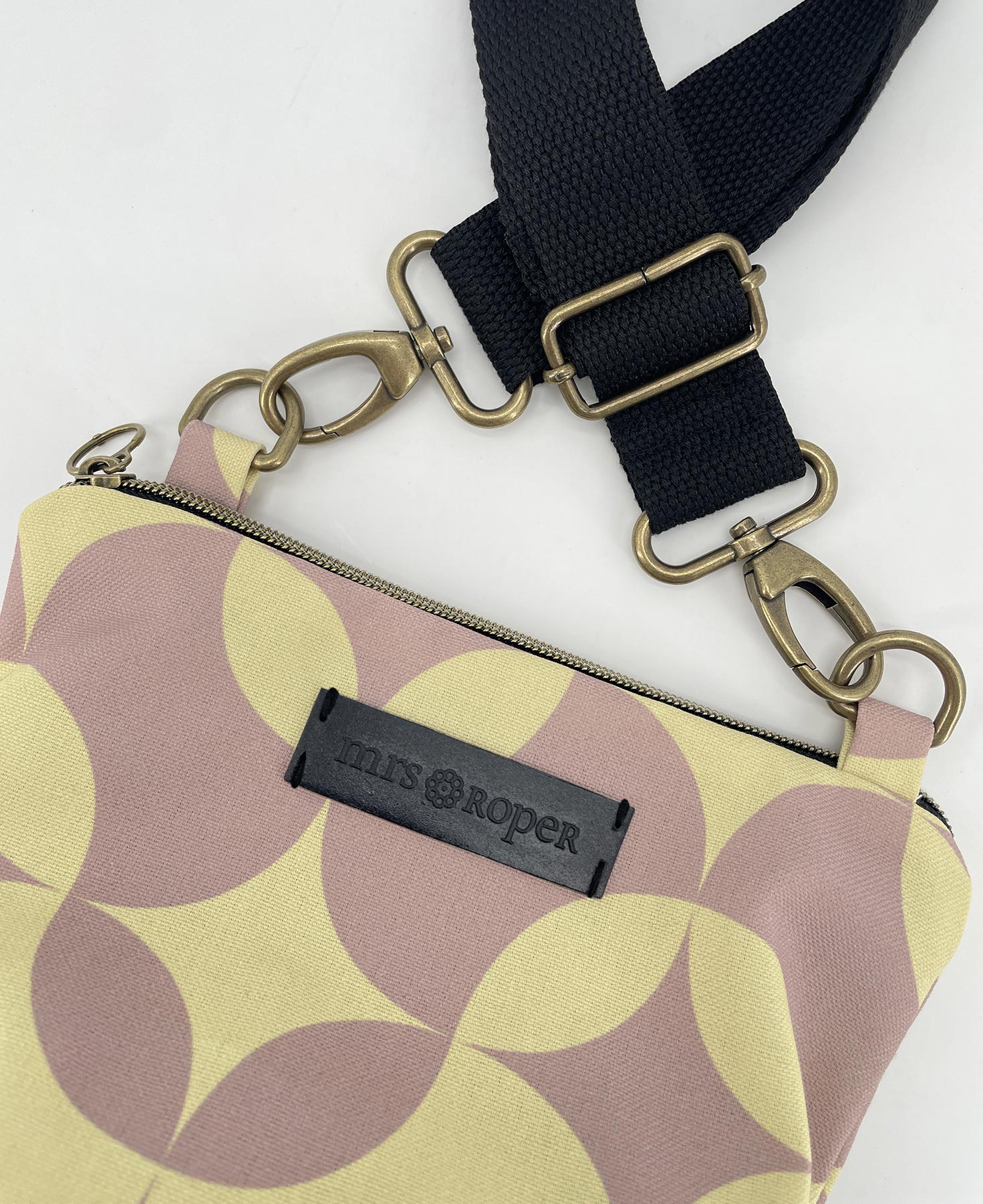 Bandolera pequeña de mujer realizada en tejido reciclado RPET con estampado geométrico de ondas en lila y vainilla, de la marca Mrs. Roper.