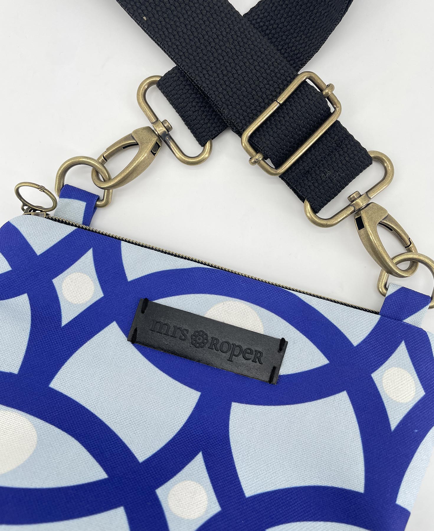 Bandolera pequeña de mujer realizada en tejido reciclado RPET con estampado geométrico en azul, de la marca Mrs. Roper.