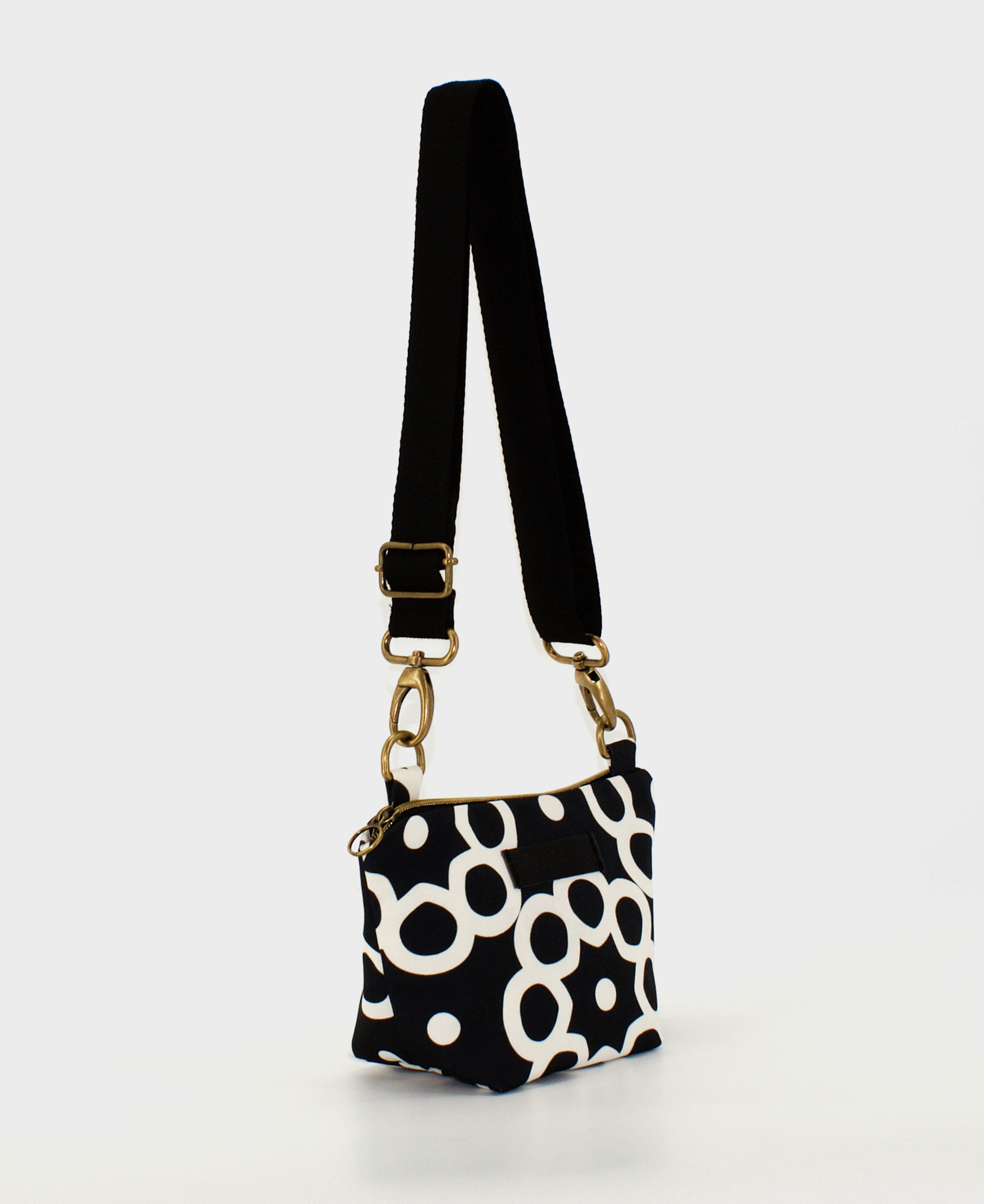 Bandolera pequeña de mujer, realizada en tejido reciclado RPET con estampado geométrico en negro y blanco, de la marca Mrs. Roper.