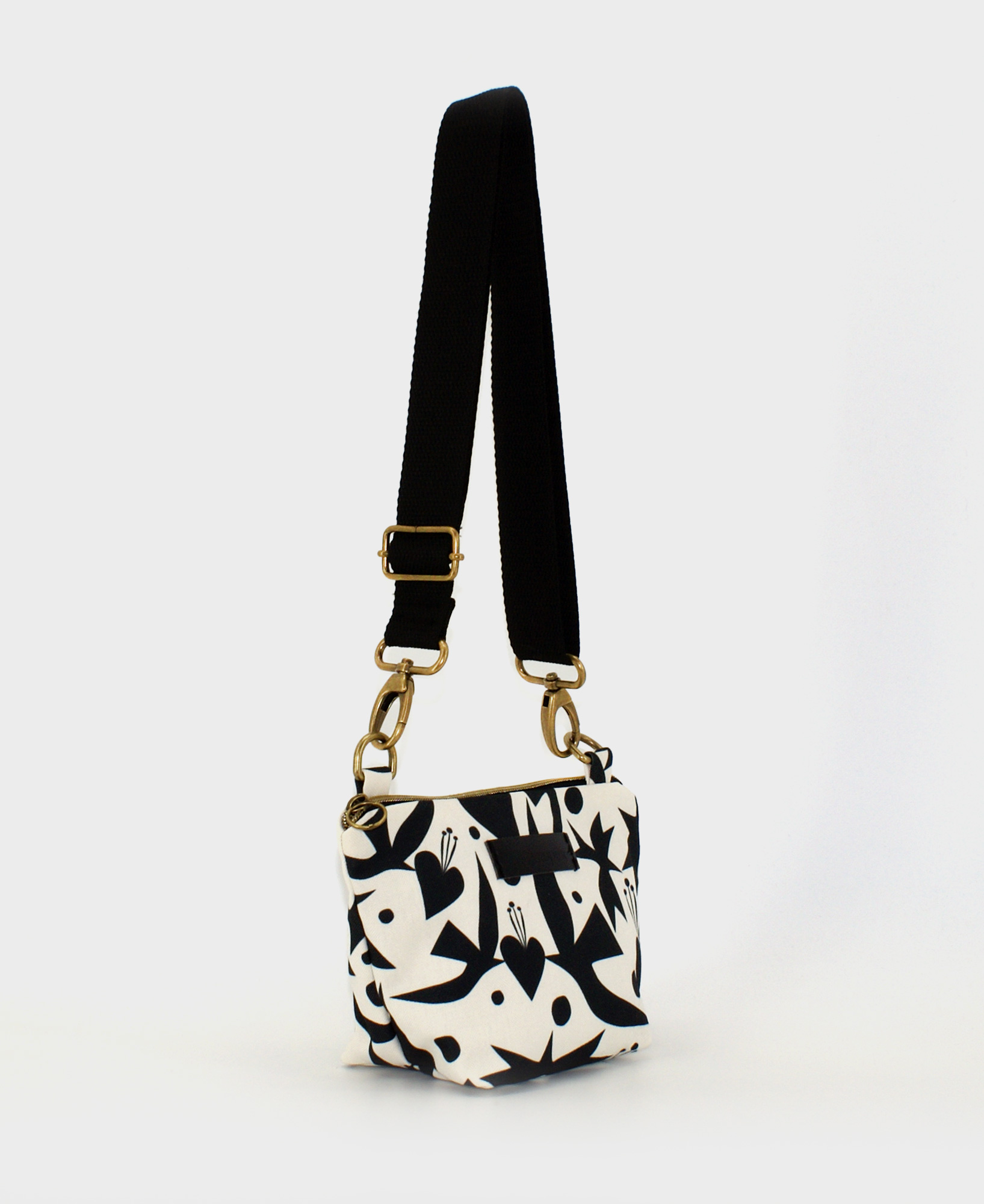 Bandolera pequeña de mujer, realizada en tejido reciclado RPET con estampado de pájaros y corazones en blanco y negro, de la marca Mrs. Roper.