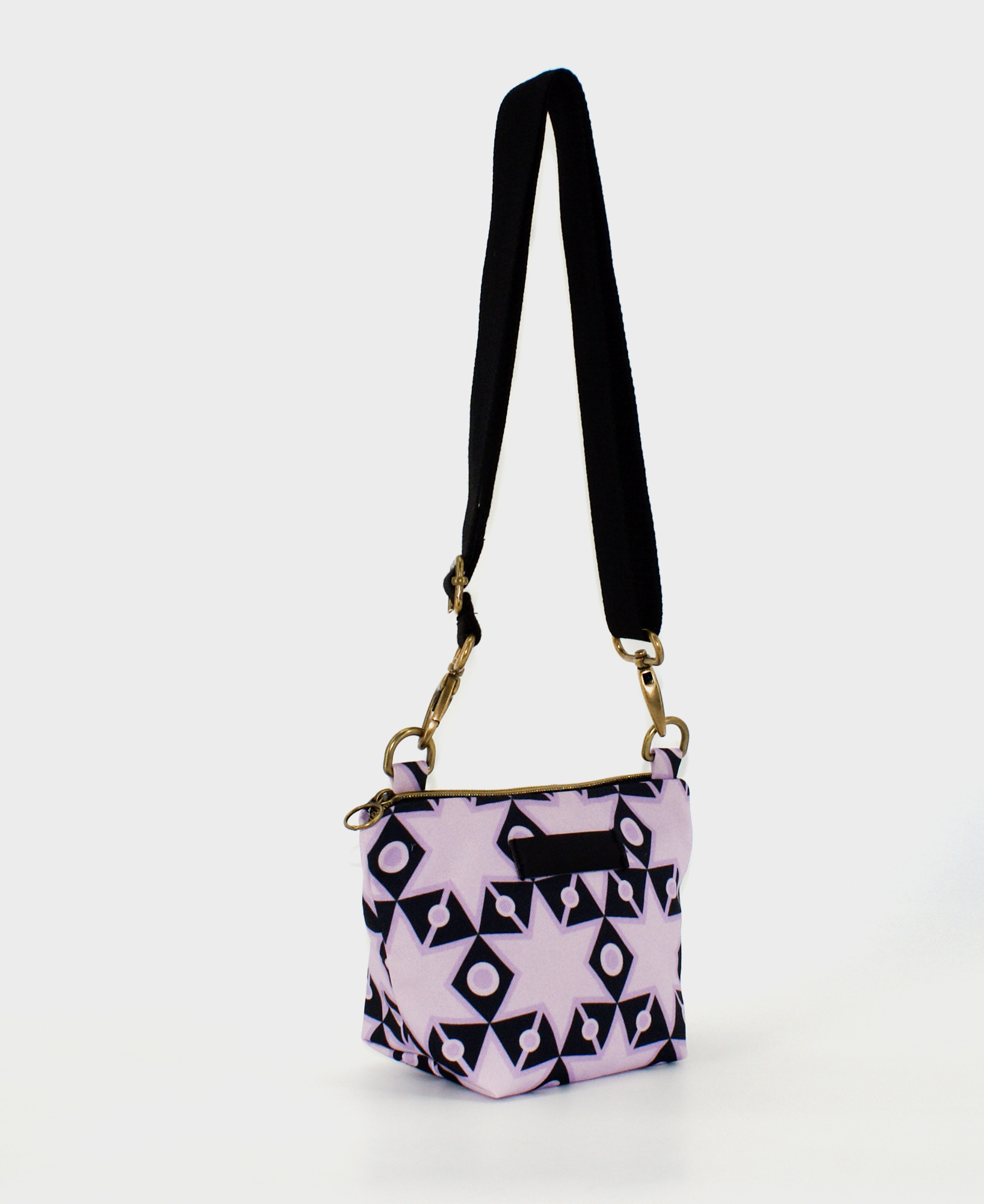 Bandolera pequeña de mujer, realizada en tejido reciclado RPET con estampado geométrico de estrellas en morado y negro, de la marca Mrs. Roper.