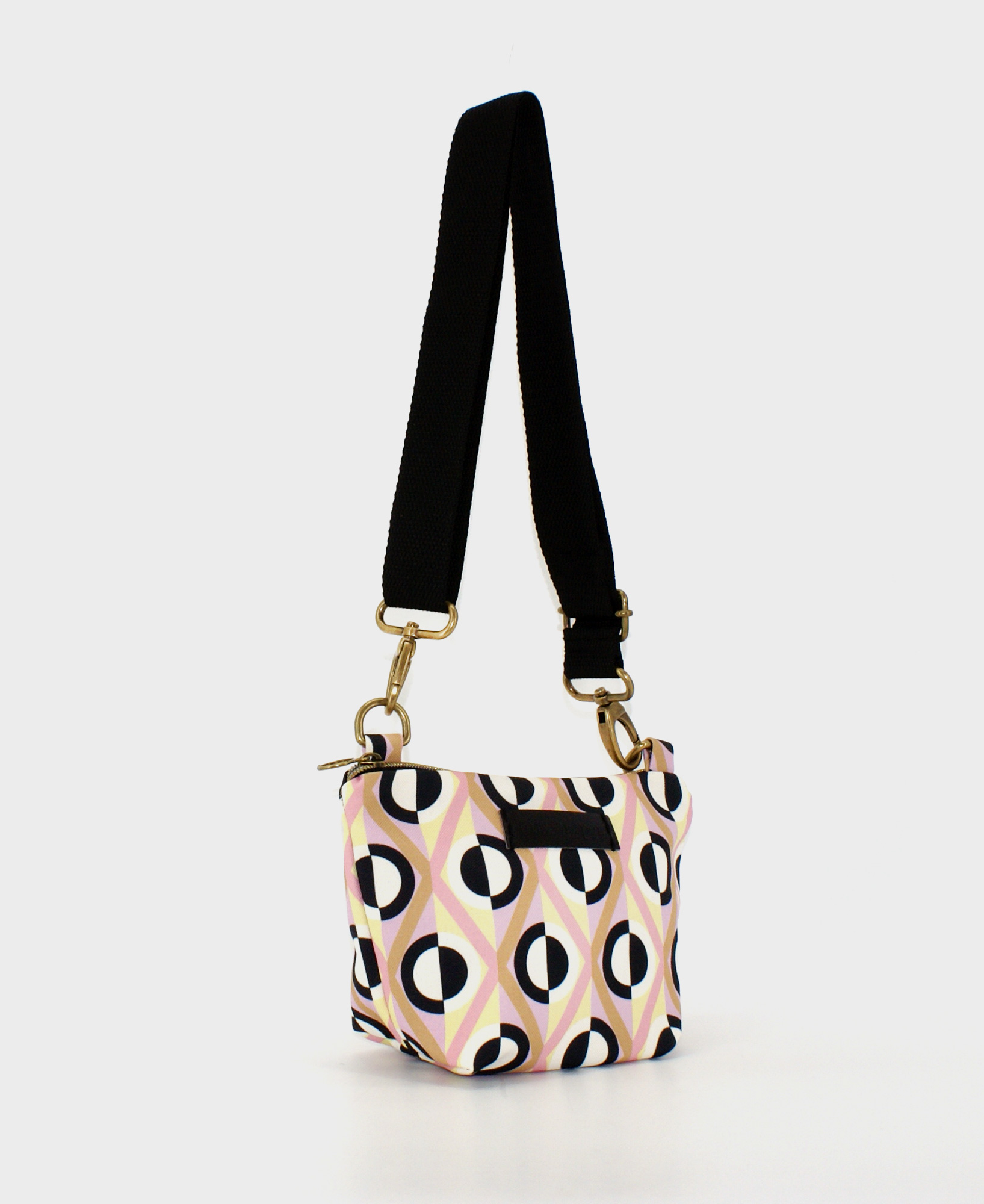 Bandolera pequeña de mujer, realizada en tejido reciclado RPET con estampado geométrico de rombos y rayas en beige, rosa, blanco y negro de la marca Mrs. Roper