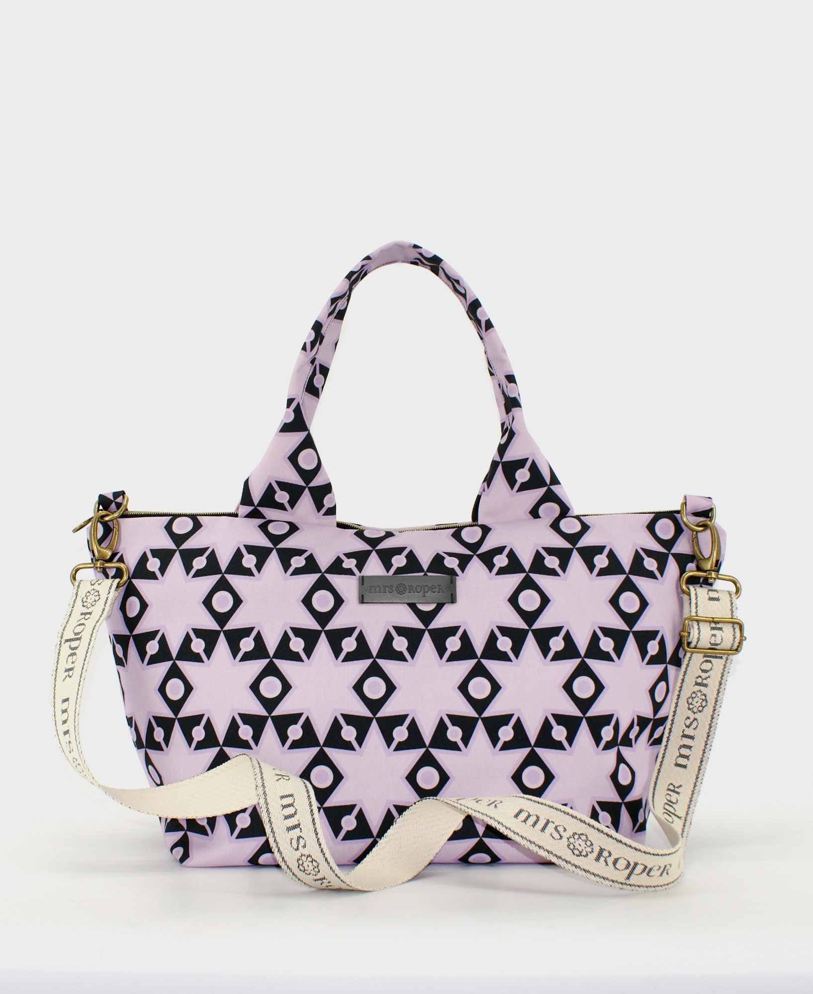 Bolso de hombro de mujer, con estampado geométrico de estrellas moradas sobre fondo negro, realizado en tejido reciclado RPET de la marca Mrs. Roper.