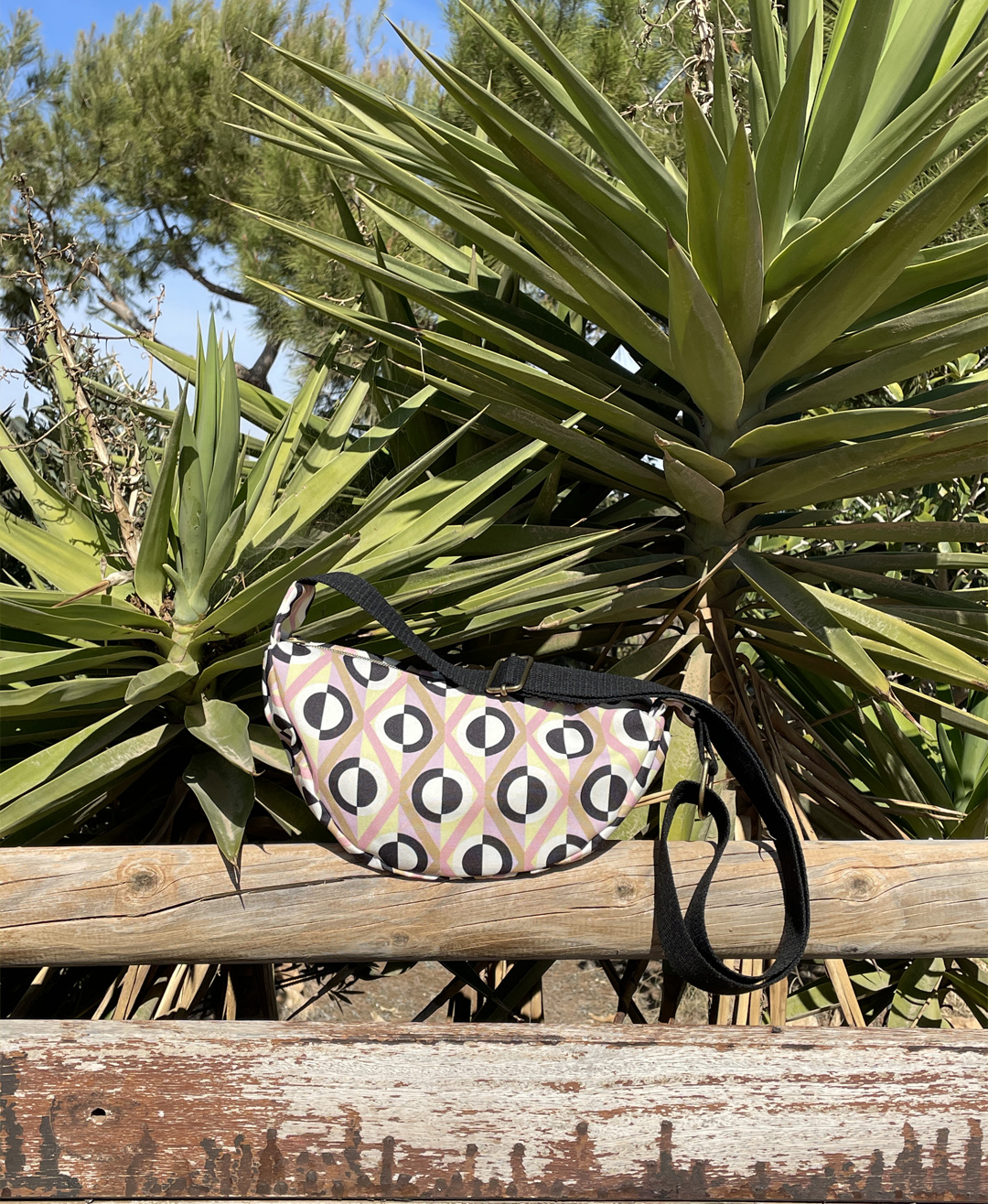 Bandolera semicircular con estampado de rombos geométrico en rosa, beige, negro y blanco hecha en tejido reciclado RPET de la marca mrs Roper.