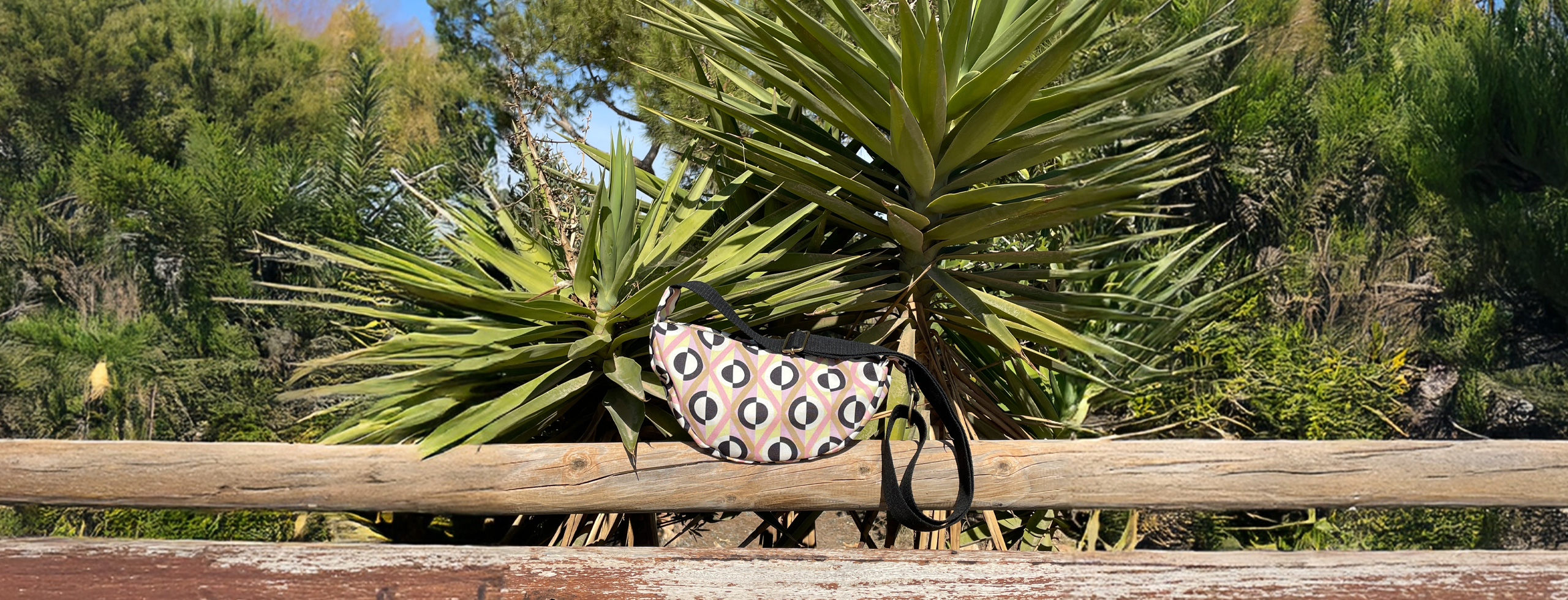 Bandolera semicircular con estampado de rombos geométrico en rosa, beige, negro y blanco hecha en tejido reciclado RPET de la marca mrs Roper.