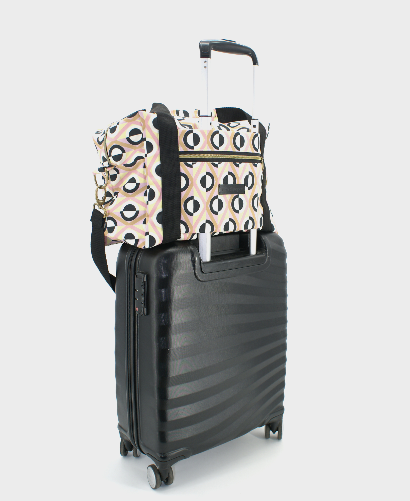 Bolsa de viaje con estampado de rombos geométrico en rosa, beige, blanco y negro, realizada en tejido RPET de la marca mrs Roper.