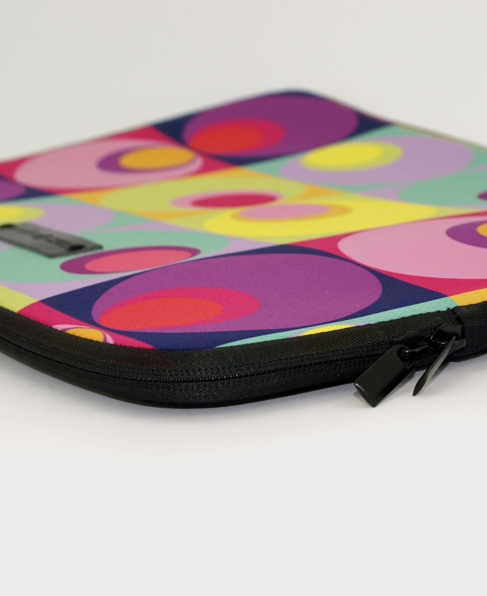 Funda de ordenador con estampado geométrico de círculos multicolor, hecha en neopreno de la marca mrs Roper.