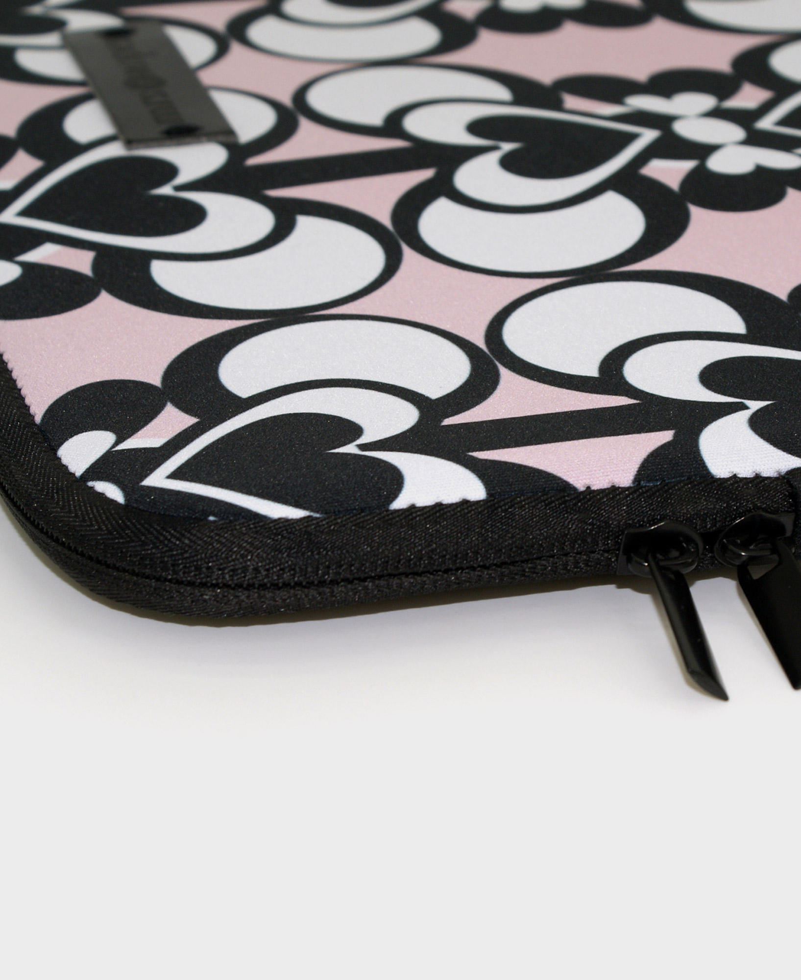Funda de ordenador con estampado geométrico de corazones blanco, negro y rosa, hecha en neopreno de la marca mrs Roper.