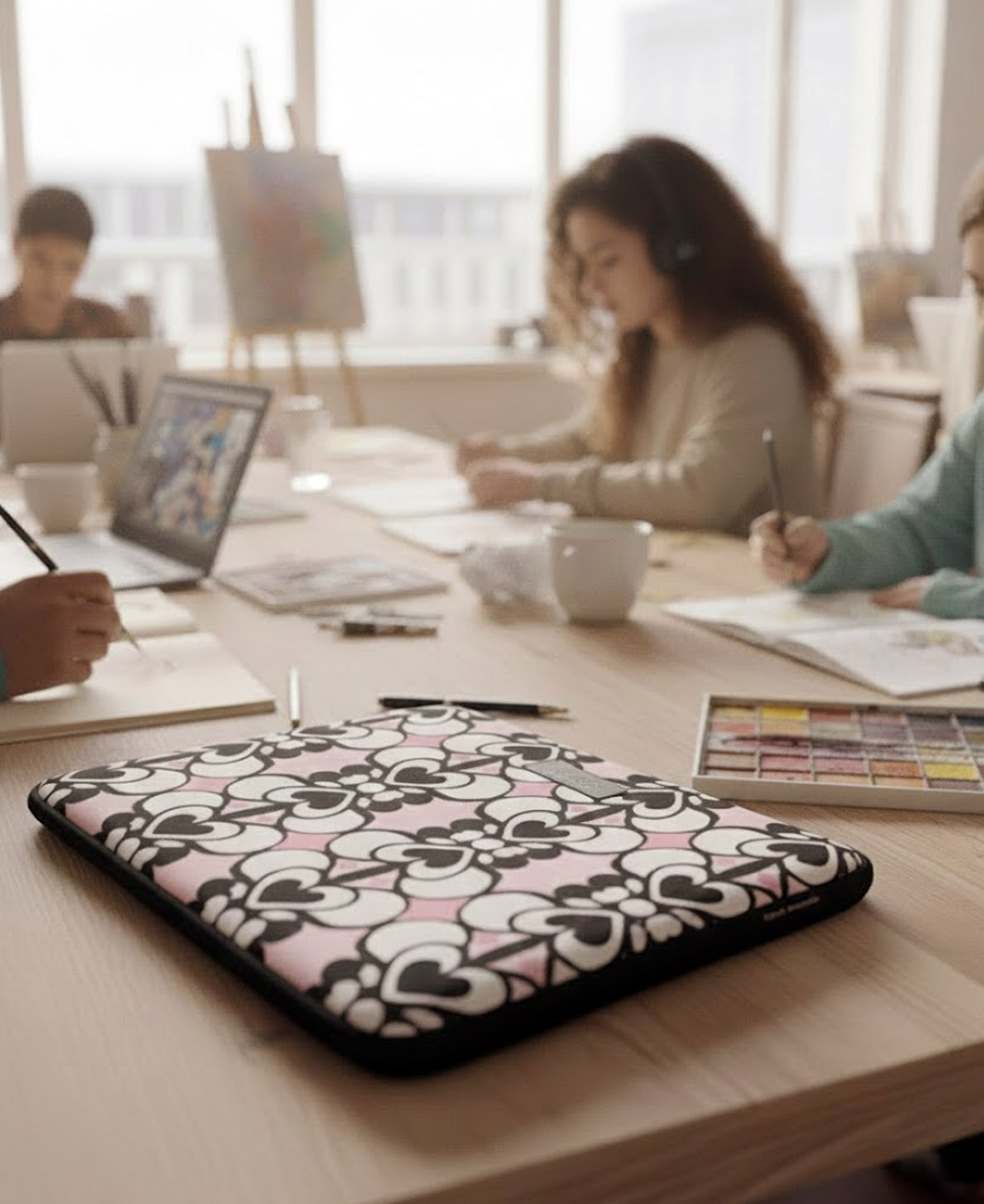 Funda de ordenador con estampado geométrico de corazones blanco, negro y rosa, hecha en neopreno de la marca mrs Roper.