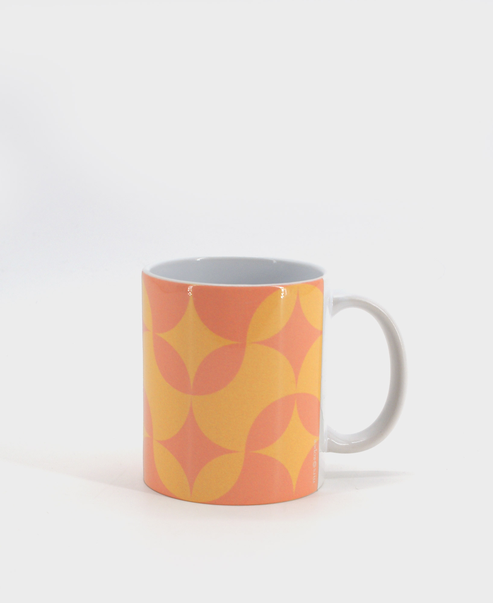 Taza tipo mug con estampado geométrico en color naranja.